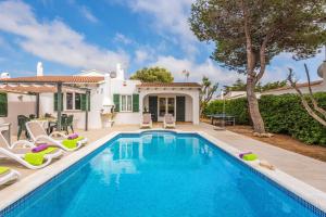 una piscina frente a una casa con sillas en Villa Isi by Villa Plus, en Cala en Blanes