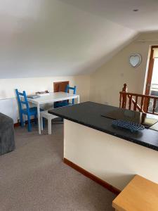 a kitchen and dining room with a table and chairs at The Loft at Duffryn Mawr Self Catering Cottages in Hensol