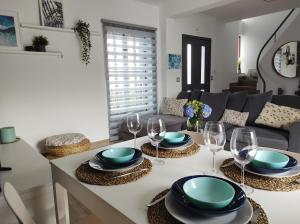 una sala de estar con una mesa con platos y copas de vino en Villa Kai Casa frente al mar y completamente restaurada, en Santa Cruz das Flores