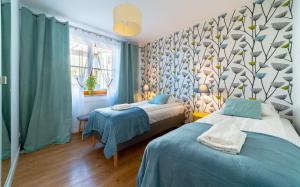 カルパチにあるApartamenty Sun & Snow Komuny Paryskiejのベッドルーム1室(ベッド2台付)、壁に木の壁が備わります。