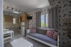 a living room with a couch and a kitchen at Potamaki Studios & Apartments in Stoupa