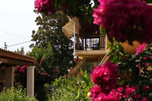 a building with pink flowers and a balcony at Nefeli Apartment 1st Floor in Agios Georgios