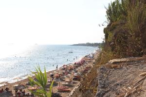 a group of people on a beach with the ocean at Nefeli Apartment 1st Floor in Agios Georgios +9 photos