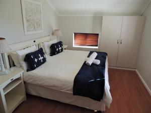 Un dormitorio con una cama con un osito de peluche encima. en 83 @ The Dunes, en Plettenberg Bay