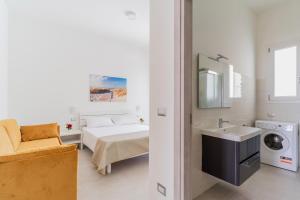 ein weißes Bad mit einem Bett und einem Waschbecken in der Unterkunft Residence Jolly Mare by BarbarHouse in Torre Lapillo