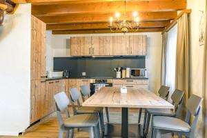 a kitchen with a large wooden table and chairs at Apartment Eiger - Aare Jungfrau AG in Grindelwald