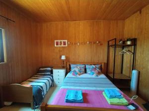 um quarto com 2 camas num quarto com paredes de madeira em Herdade da Hera em Azambuja