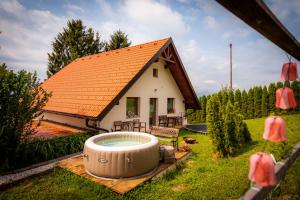 una casa con bañera de hidromasaje en el patio en Panorama Glamping Visole, en Slovenska Bistrica