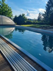 una piscina de agua azul en una terraza de madera en Villa Gamma - Lipno Home, en Lipno nad Vltavou 14 fotos más