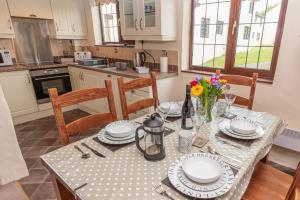 a kitchen with a table with plates and flowers on it at Providence Cottage in Woolacombe