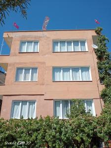 a brown building with white windows at HZD Apartments Hostel in Fethiye