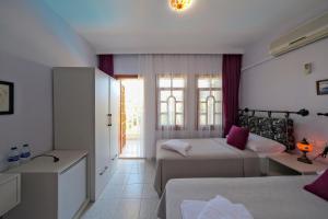 a hotel room with two beds and a window at Casablanca Hotel in Dalyan