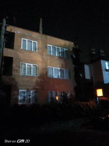 a tall brick building with windows at night at HZD Apartments Hostel in Fethiye