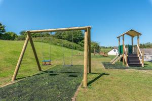 un parco giochi con altalena e scivolo di Point Cottage a Woolacombe