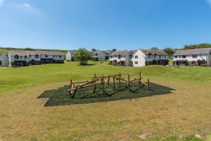 un parco giochi in un campo con case sullo sfondo di Point Cottage a Woolacombe