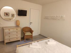 バルドリーノにあるCasa Robyのベッドルーム1室(ベッド1台、鏡、椅子付)