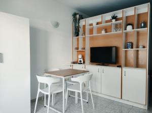 a dining room with a table and white chairs at Apartamento en la playa in Salou