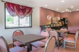 a dining room with tables and chairs and a window at Super 8 by Wyndham Pittsburgh/Monroeville in Monroeville