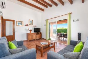 ein Wohnzimmer mit 2 blauen Sofas und einem Tisch in der Unterkunft Villa Violeta by Villa Plus in Cala'n Bosch