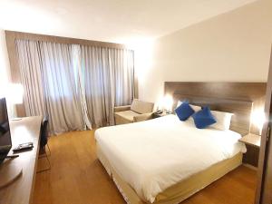 a hotel room with a large bed and a chair at Novotel Manaus in Manaus