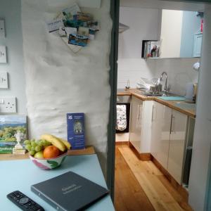 Calstock的住宿－The Artist's Retreat，厨房在柜台上放一碗水果
