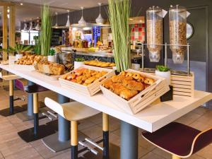 una mesa con cestas de pan y bollería. en ibis Avignon Centre Gare, en Aviñón