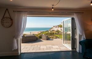 a room with a door open to the beach at The White Cottage in Woolacombe
