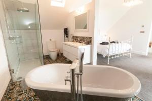 a bathroom with a tub and a sink and a shower at The White Cottage in Woolacombe +16 photos
