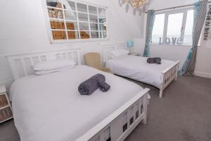 a room with two beds with towels on them at The White Cottage in Woolacombe
