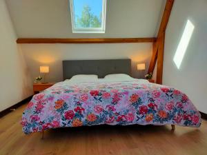 ein Schlafzimmer mit einem Bett mit geblümter Tagesdecke in der Unterkunft Maison 110 m² cosy au calme avec jardin de 1000 m² in Pont-Audemer
