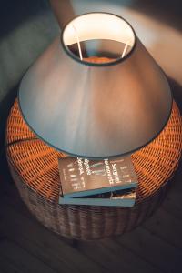 a lamp with a book on top of a basket at Gîte La Source in Grusse