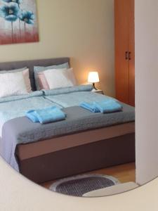 um quarto com uma cama com duas almofadas azuis em Apartman Ana em Leskovac