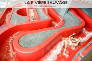 a water slide with two people in the water at Ecrin Blanc Resort Courchevel - Aquapark in Courchevel