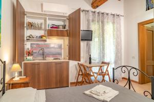 a room with a bed and a kitchen and a table at Agriturismo Al Girasole in San Donato