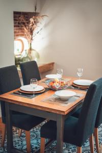 a wooden table with plates and wine glasses on it at Gîte La Source in Grusse