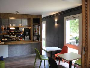 a restaurant with tables and chairs and a window at ibis budget Redon in Redon