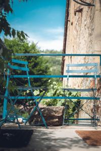 a blue chair sitting on the side of a building at Gîte La Source in Grusse