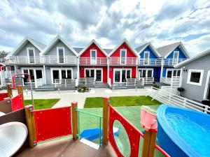 una fila de casas coloridas con parque infantil en Kotwisko en Sarbinowo