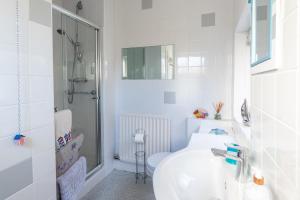a white bathroom with a sink and a shower at Heatherdale in Mortehoe +22 photos