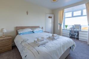 a bedroom with a large bed with towels on it at Heatherdale in Mortehoe