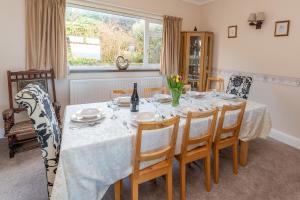 a dining room with a white table and chairs at Heatherdale in Mortehoe