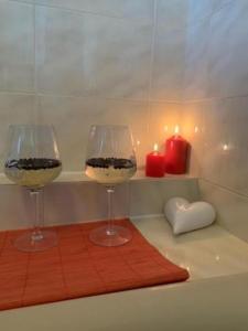 two wine glasses sitting on a bath tub with candles at Romantic room for two persons in Poreč