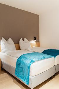 a large white bed with a blue blanket on it at Villa Kranebitt in Bressanone +32 photos
