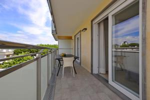 - Balcón con mesa y sillas en un edificio en Appartamenti Mare, en Lignano Sabbiadoro