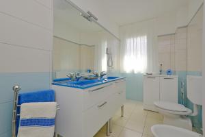 een badkamer met een wastafel en een toilet bij Appartamenti Mare in Lignano Sabbiadoro