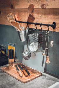 una encimera de cocina con utensilios en una tabla de cortar en Gîte La Source, en Grusse