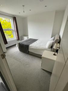 a bedroom with a bed and a window at NKY CLASSIC BRIXTON APARTMENT Three in London
