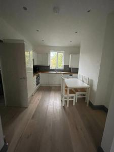 a kitchen with a table and chairs in a room at NKY CLASSIC BRIXTON APARTMENT Three in London