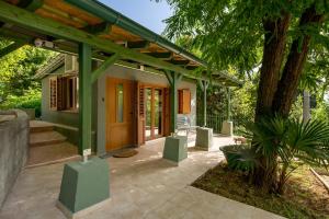 Cute & Green في أوباتيا: منزل به سقف أخضر وفناء
