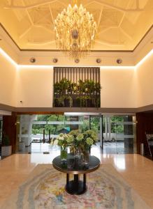 a large lobby with a table and a chandelier at The Oasis Mussoorie - A Member of Radisson Individuals in Mussoorie